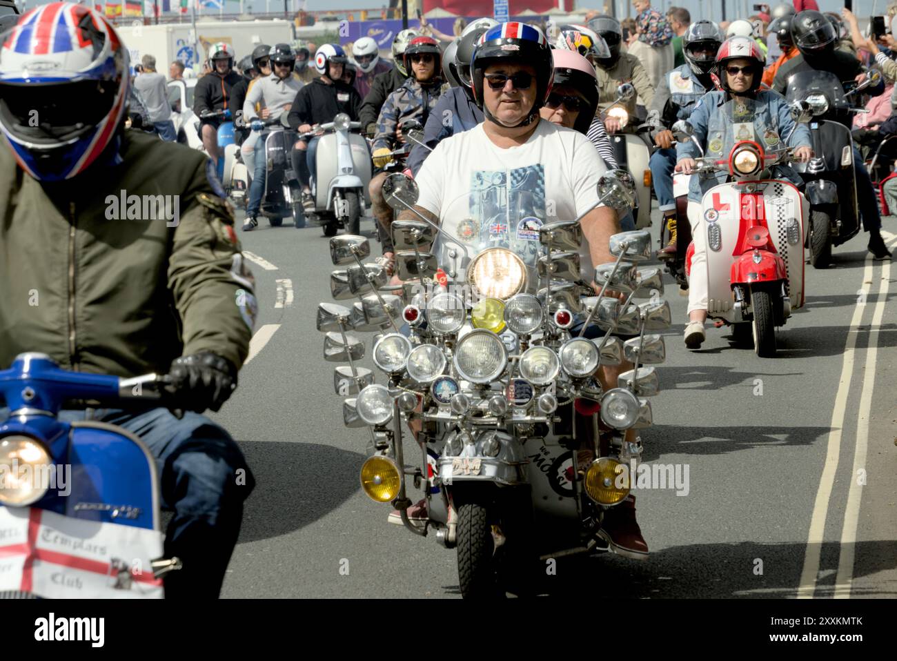 Un uomo in sella a uno scooter d'epoca all'Isola di Wight, Regno Unito Scooter Rally 2024 con molti specchi sul suo scooter. Foto Stock