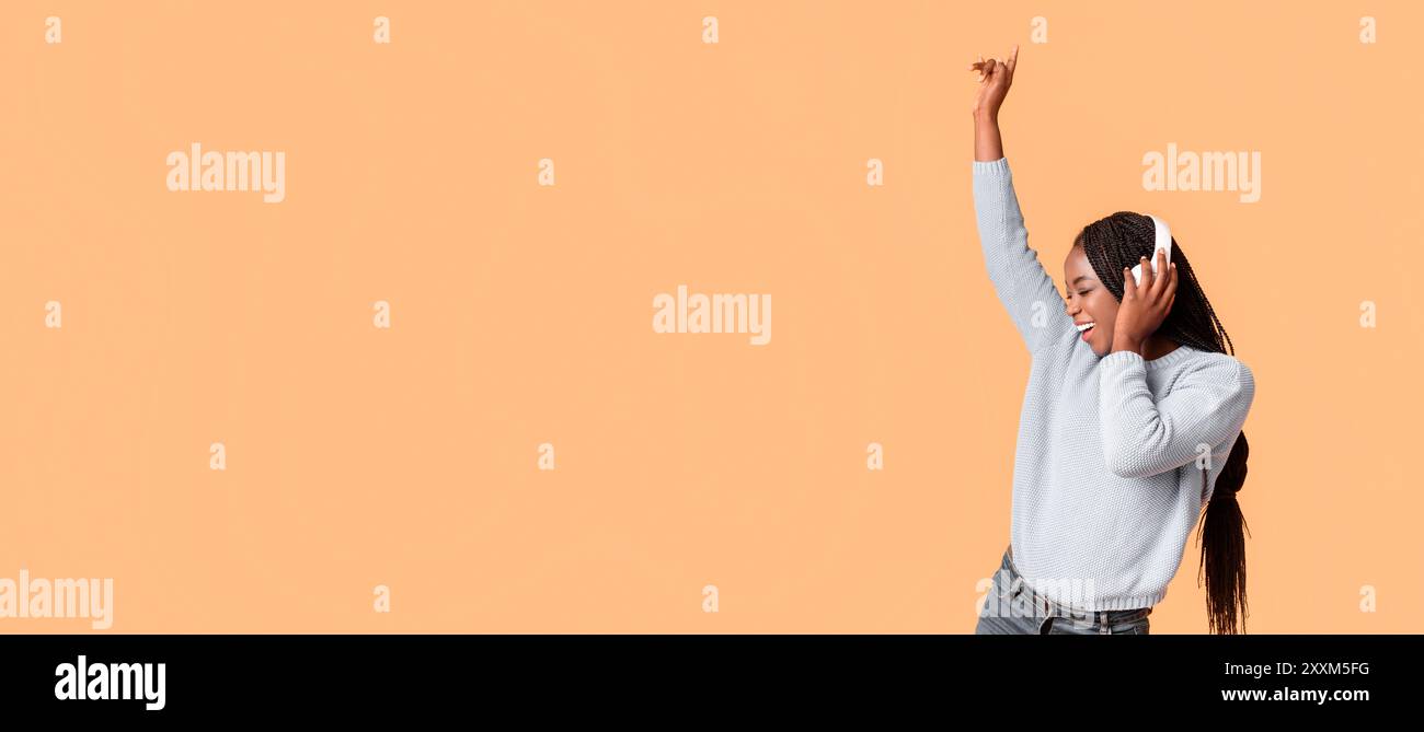 Joyful Young Woman Dancing mentre ascoltano musica Foto Stock