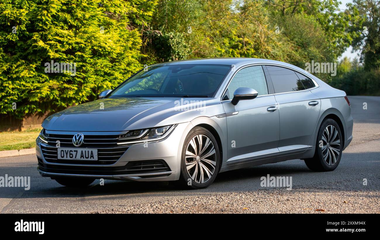 Whittlebury, Northants., Regno Unito - 25 agosto 2024: Auto diesel Volkswagen Arteon argento 2017 che guida su una strada di campagna britannica. Foto Stock