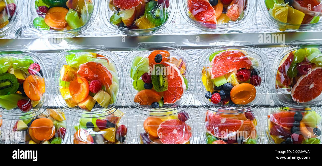 Scatole di plastica con macedonie di frutta preconfezionate, messe in vendita in un frigorifero commerciale Foto Stock
