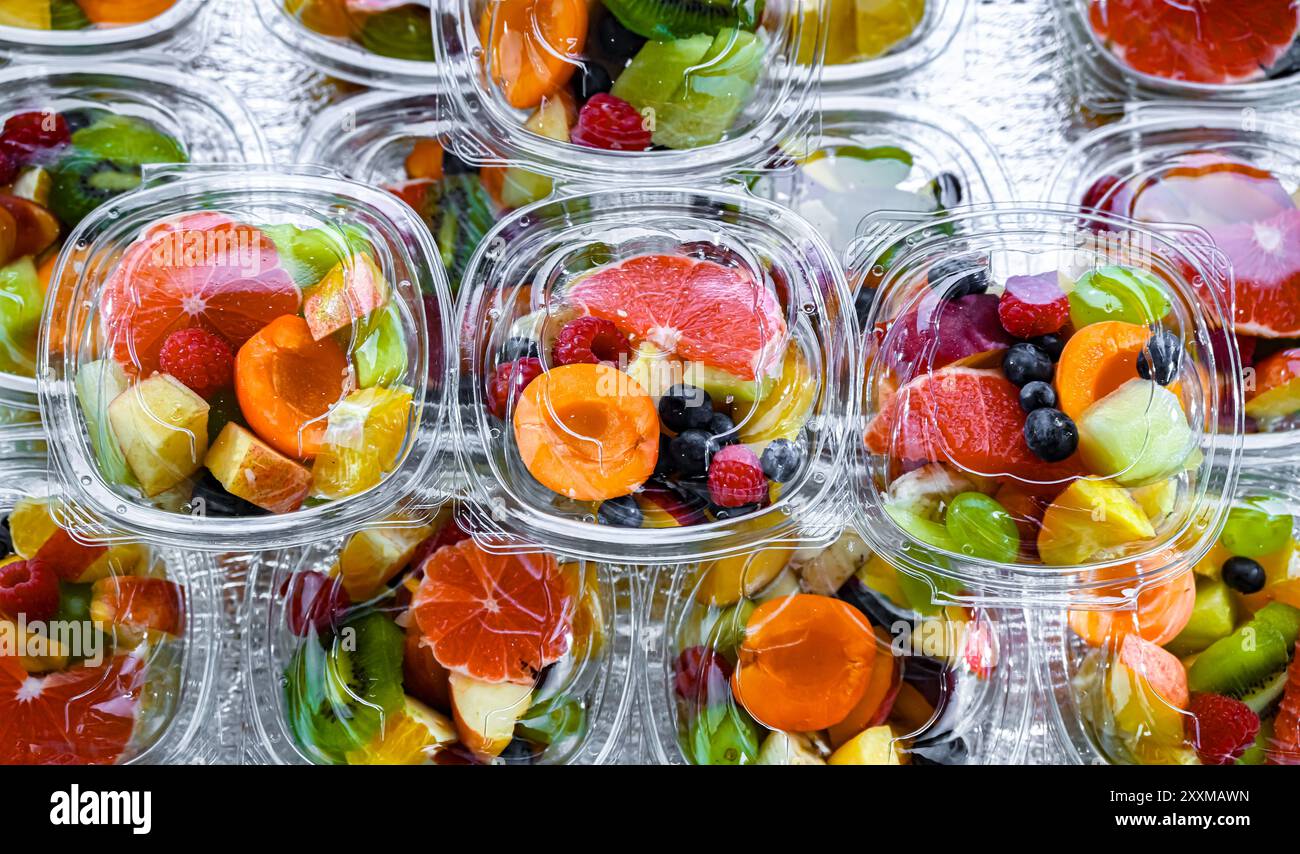 Scatole di plastica con macedonie di frutta preconfezionate, messe in vendita in un frigorifero commerciale Foto Stock