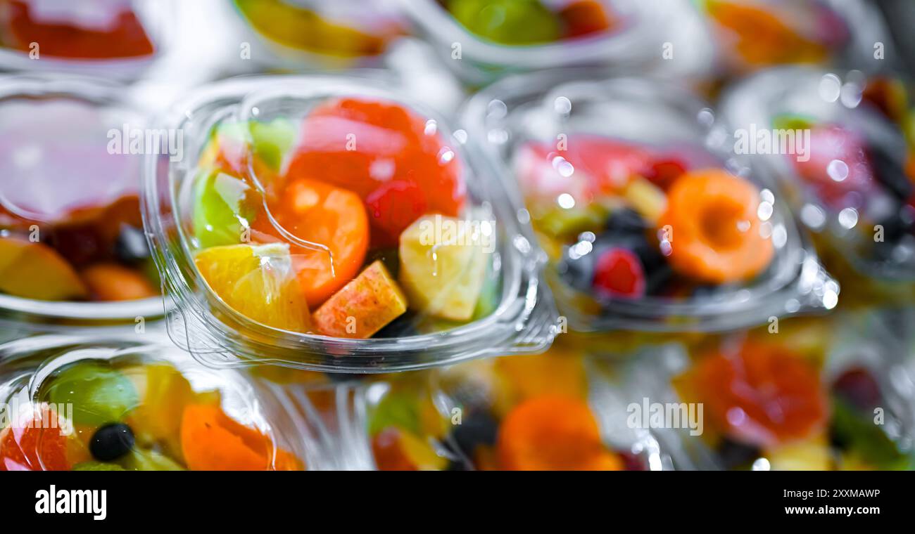 Scatole di plastica con macedonie di frutta preconfezionate, messe in vendita in un frigorifero commerciale Foto Stock