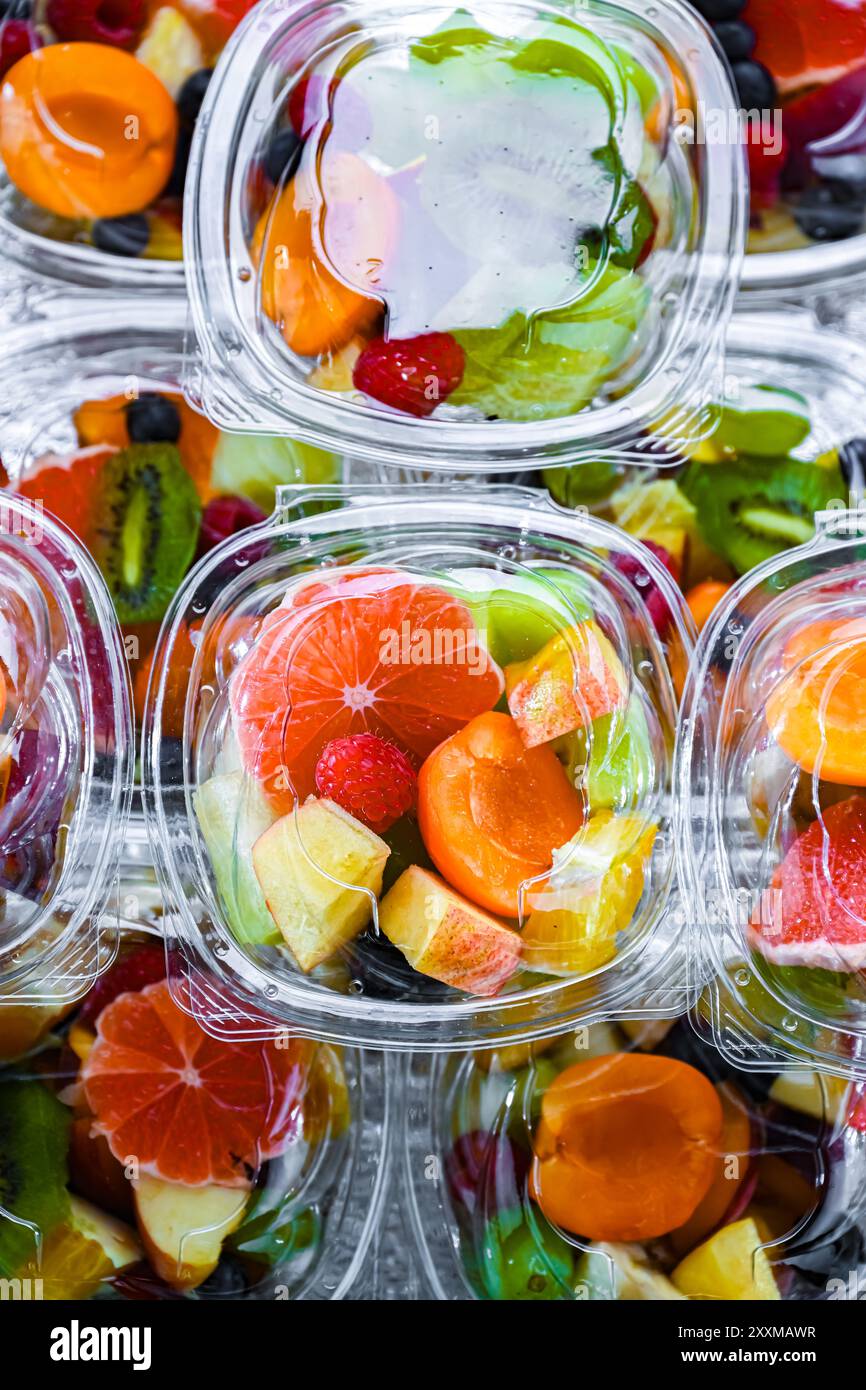 Scatole di plastica con macedonie di frutta preconfezionate, messe in vendita in un frigorifero commerciale Foto Stock