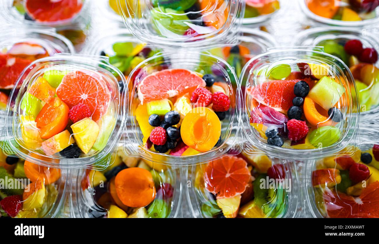 Scatole di plastica con macedonie di frutta preconfezionate, messe in vendita in un frigorifero commerciale Foto Stock