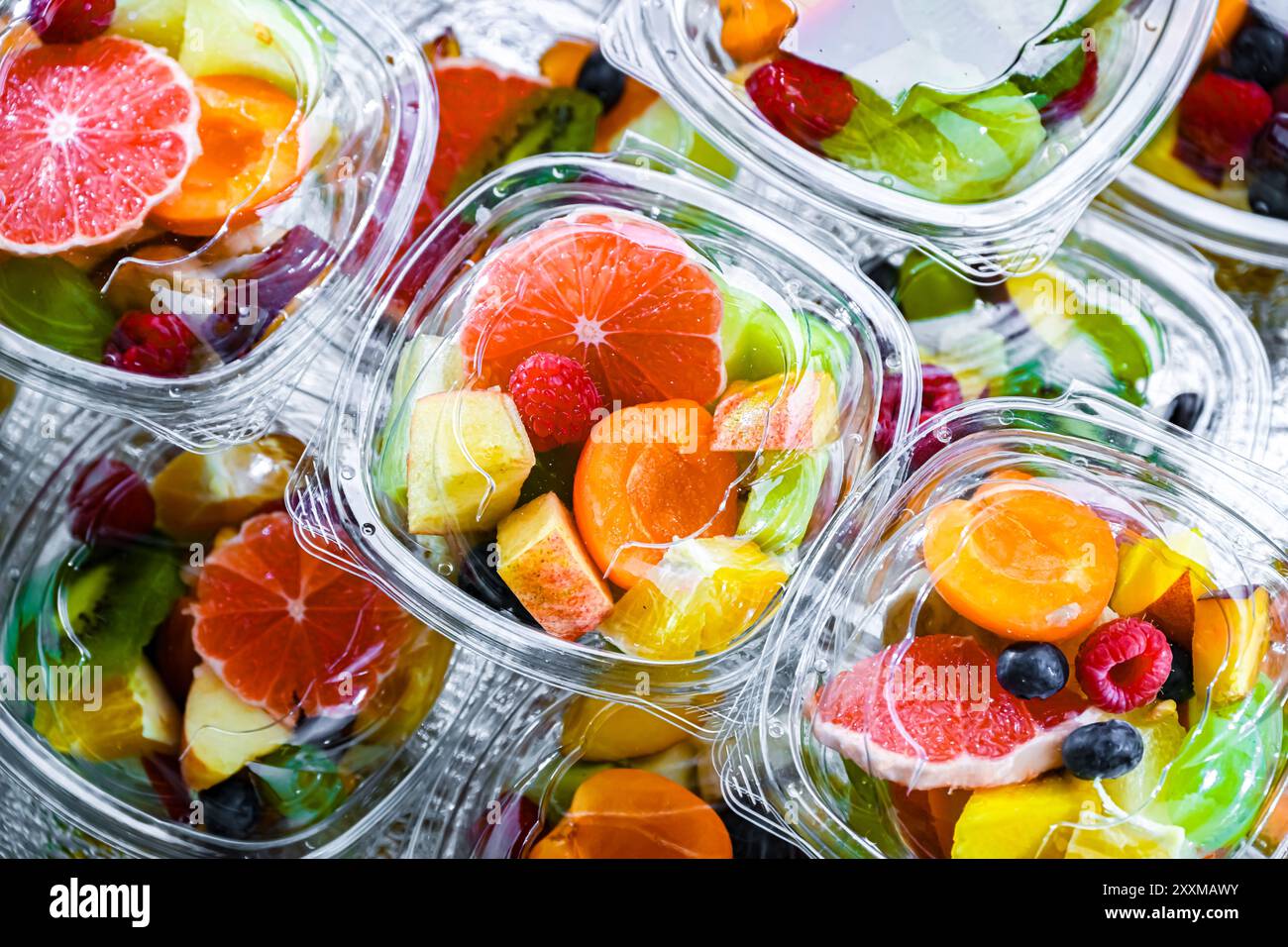 Scatole di plastica con macedonie di frutta preconfezionate, messe in vendita in un frigorifero commerciale Foto Stock