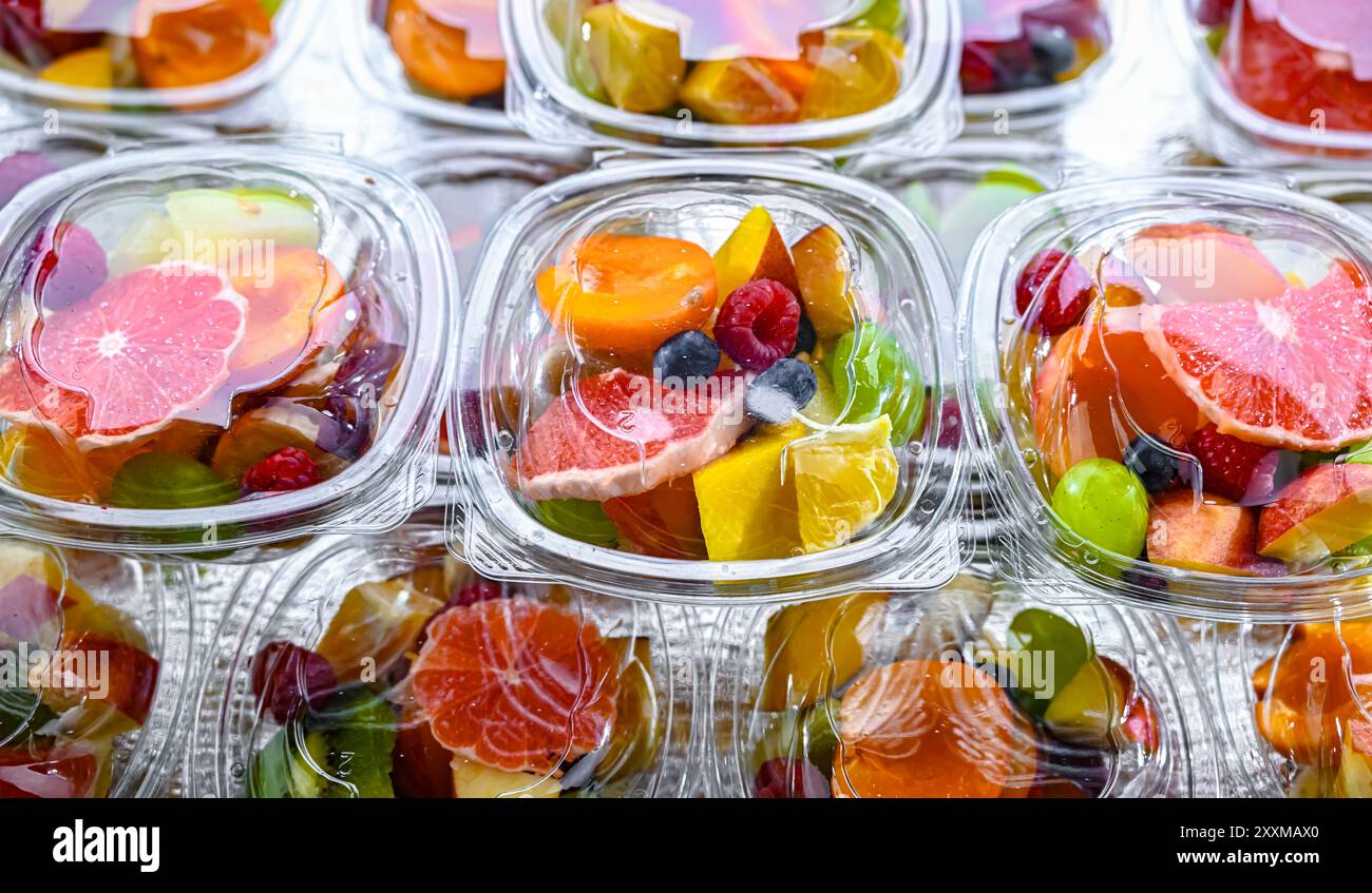 Scatole di plastica con macedonie di frutta preconfezionate, messe in vendita in un frigorifero commerciale Foto Stock