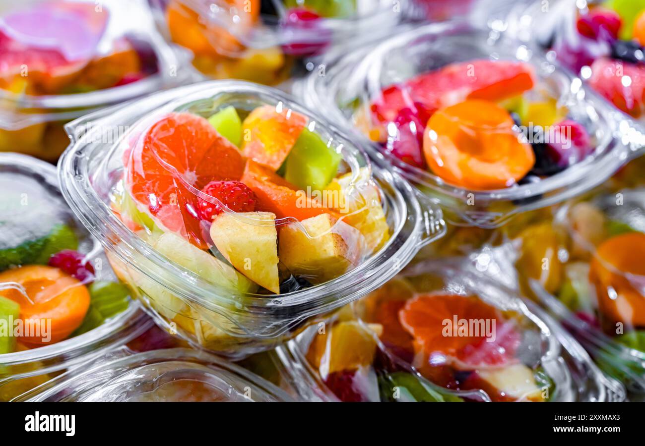 Scatole di plastica con macedonie di frutta preconfezionate, messe in vendita in un frigorifero commerciale Foto Stock