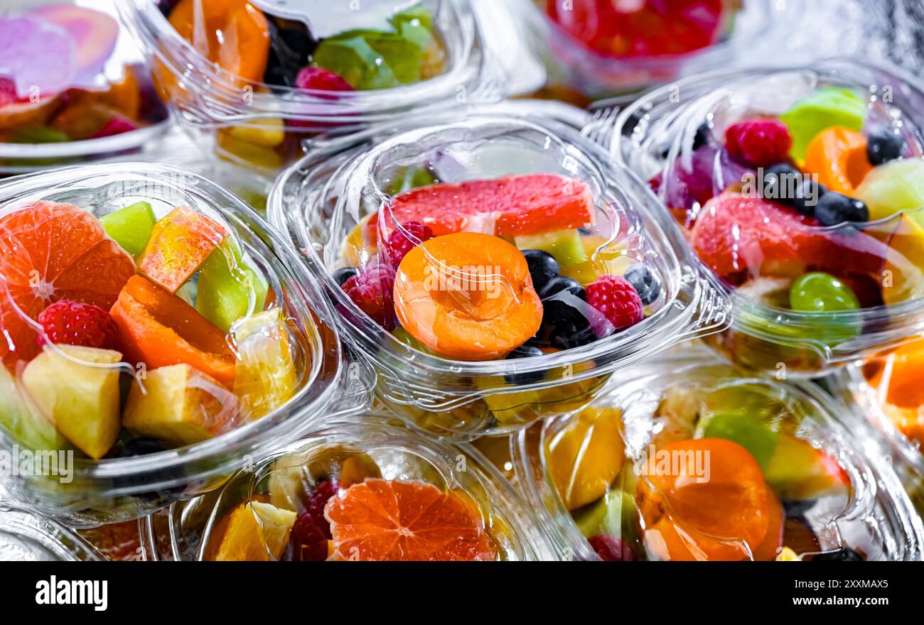 Scatole di plastica con macedonie di frutta preconfezionate, messe in vendita in un frigorifero commerciale Foto Stock