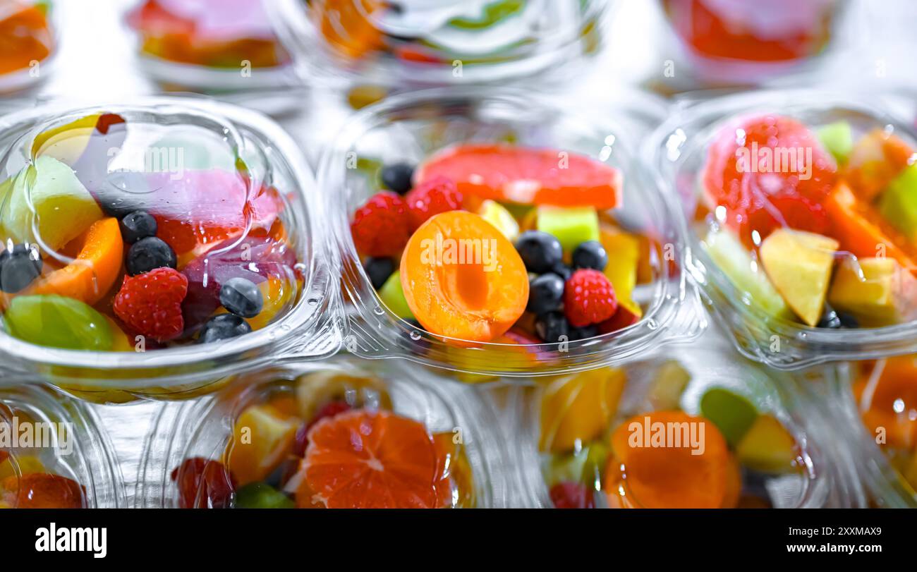 Scatole di plastica con macedonie di frutta preconfezionate, messe in vendita in un frigorifero commerciale Foto Stock