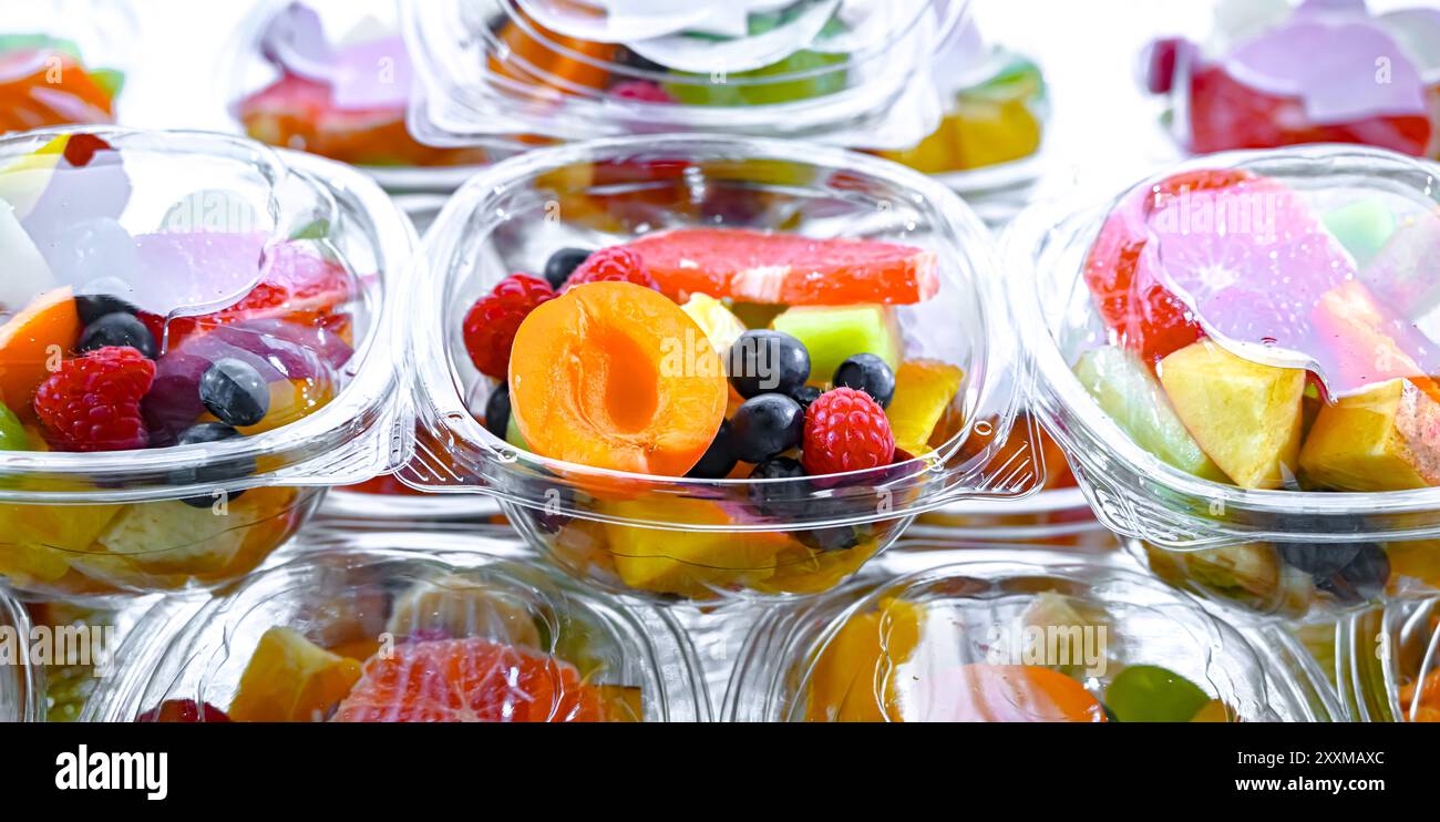 Scatole di plastica con macedonie di frutta preconfezionate, messe in vendita in un frigorifero commerciale Foto Stock