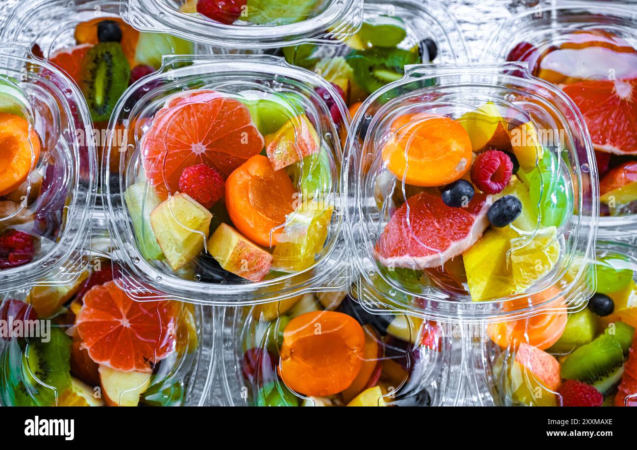 Scatole di plastica con macedonie di frutta preconfezionate, messe in vendita in un frigorifero commerciale Foto Stock