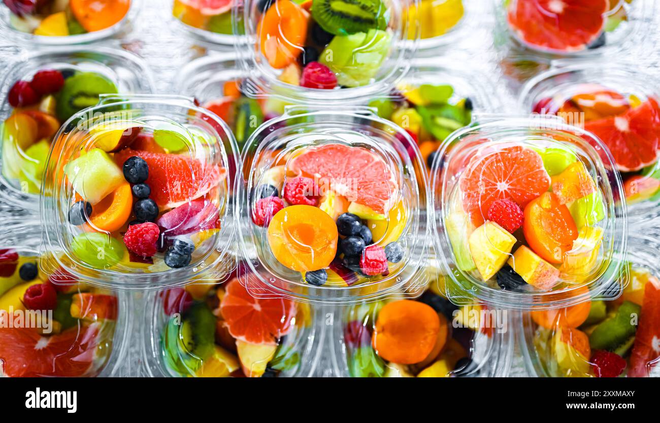 Scatole di plastica con macedonie di frutta preconfezionate, messe in vendita in un frigorifero commerciale Foto Stock