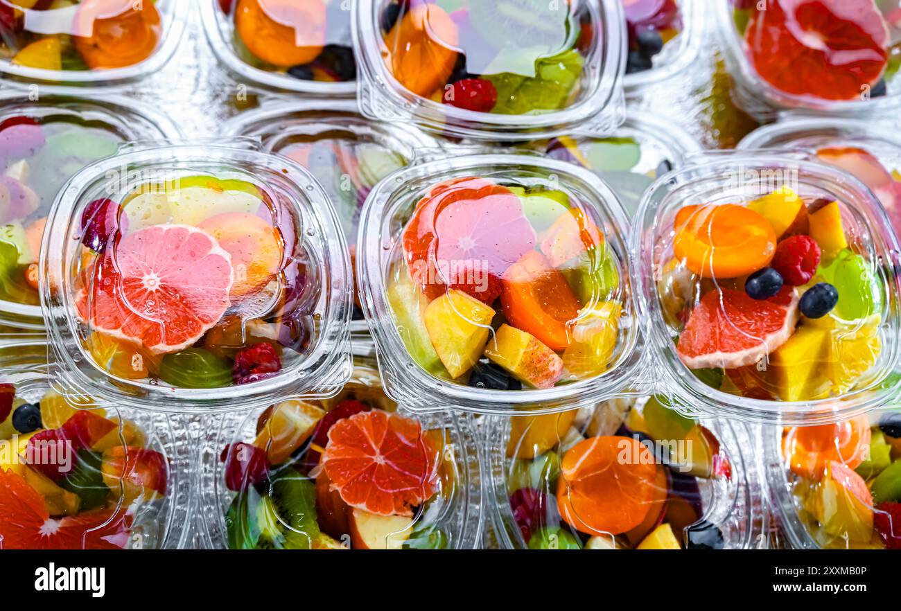 Scatole di plastica con macedonie di frutta preconfezionate, messe in vendita in un frigorifero commerciale Foto Stock