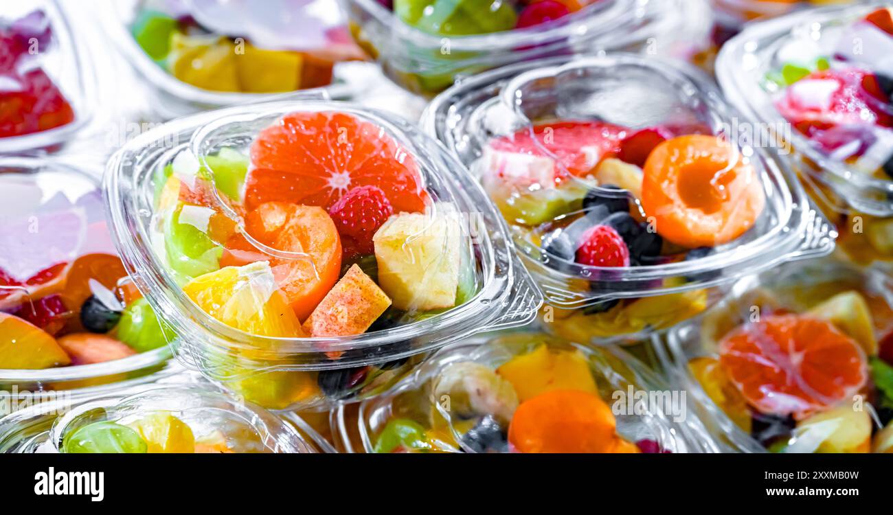 Scatole di plastica con macedonie di frutta preconfezionate, messe in vendita in un frigorifero commerciale Foto Stock