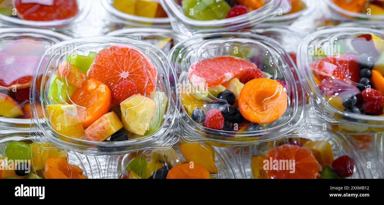 Scatole di plastica con macedonie di frutta preconfezionate, messe in vendita in un frigorifero commerciale Foto Stock