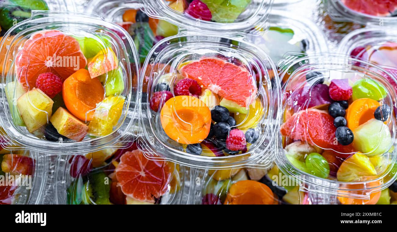 Scatole di plastica con macedonie di frutta preconfezionate, messe in vendita in un frigorifero commerciale Foto Stock