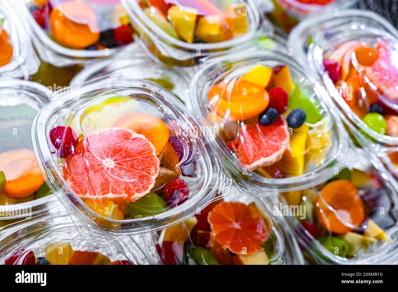 Scatole di plastica con macedonie di frutta preconfezionate, messe in vendita in un frigorifero commerciale Foto Stock