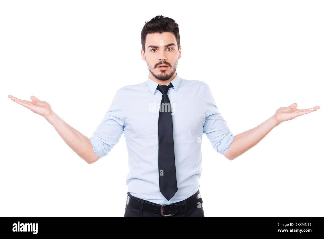 E' difficile scegliere! Giovane frustrato in camicia e cravatta che tiene gli spazi di copia in entrambe le mani e guarda la fotocamera mentre si trova contro lo sfondo bianco Foto Stock