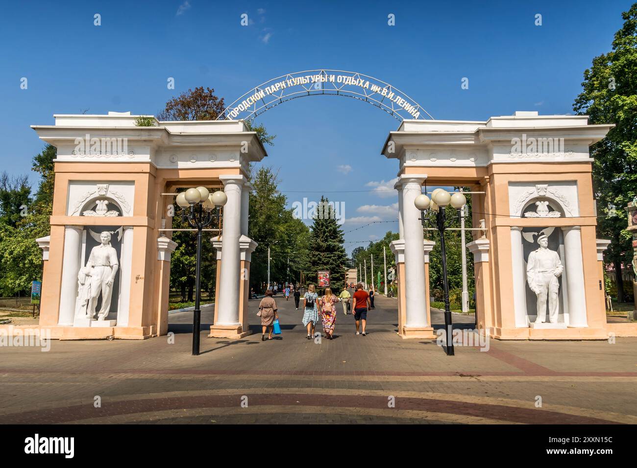 L'ingresso in stile sovietico al parco cittadino di Belgorod, Russia, con il popolo russo che cammina durante il fine settimana. Foto Stock