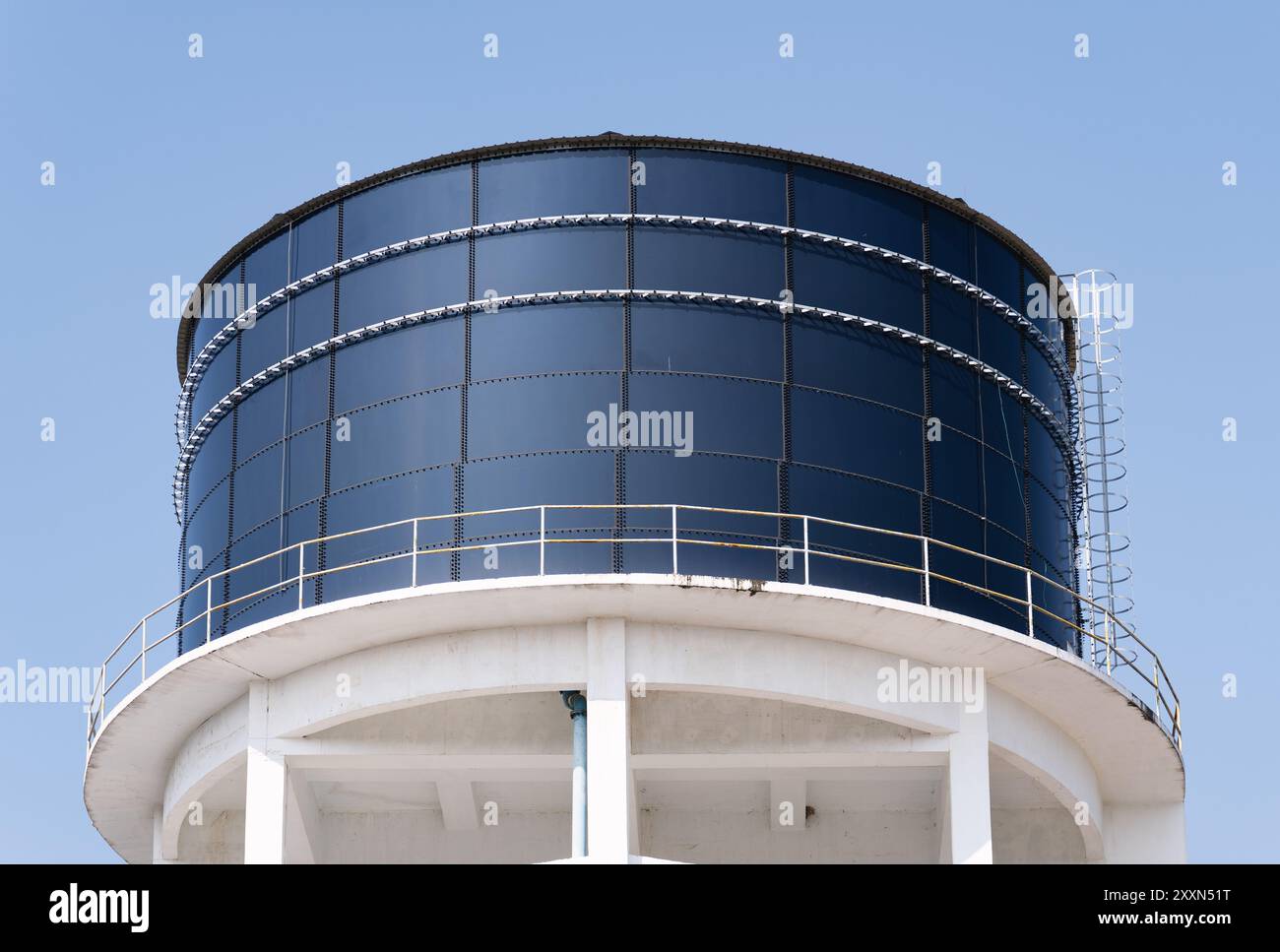 Grande serbatoio dell'acqua industriale rialzato contro un cielo azzurro. Foto Stock