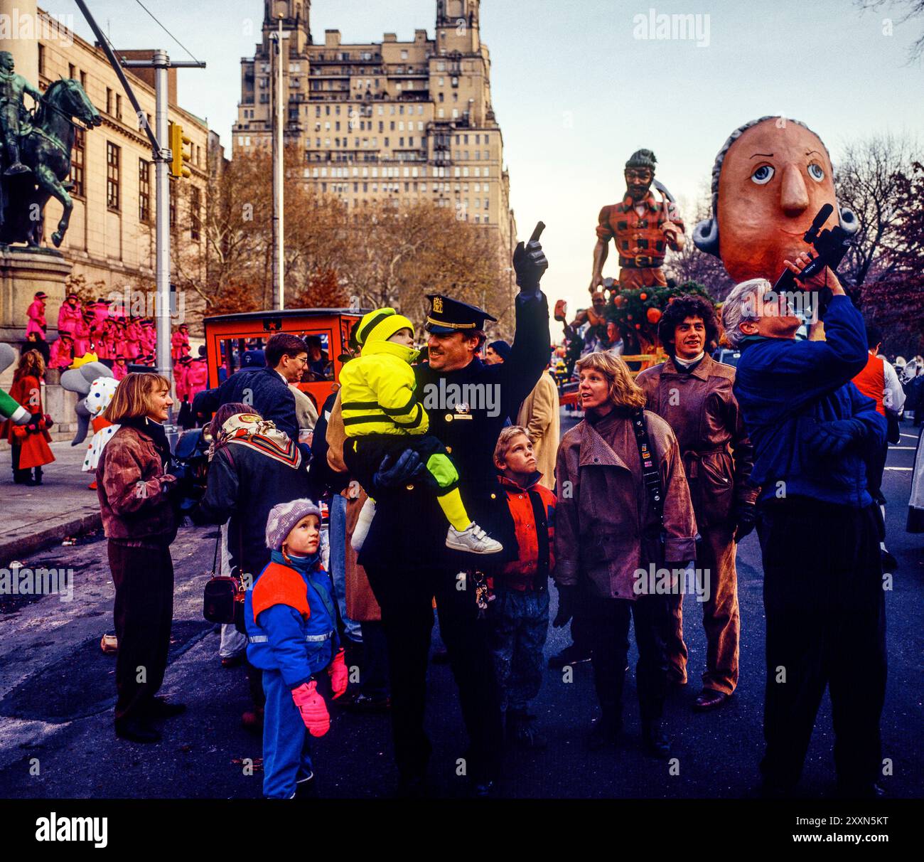 New York, 28 novembre 1991, agente di polizia che trasporta bambino piccolo, gente, Macy's Thanksgiving Day Parade, New York City, NYC, NY, stato di New York, STATI UNITI, Foto Stock