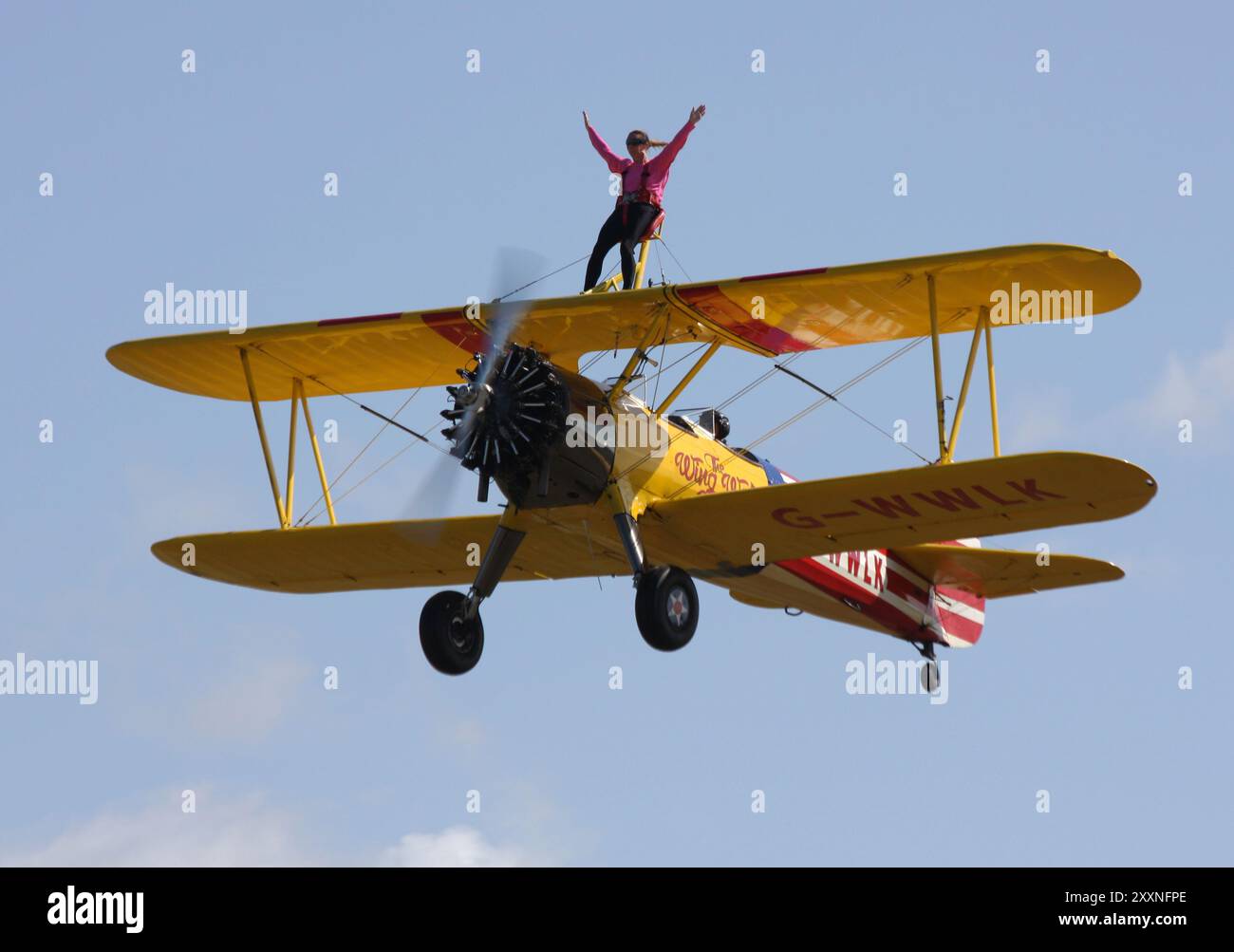 Un camminatore delle ali si gode un giro su un Boeing A-75L300 Stearman della Wing Walk Company presso l'Headcorn Aeodrome nel Kent Foto Stock