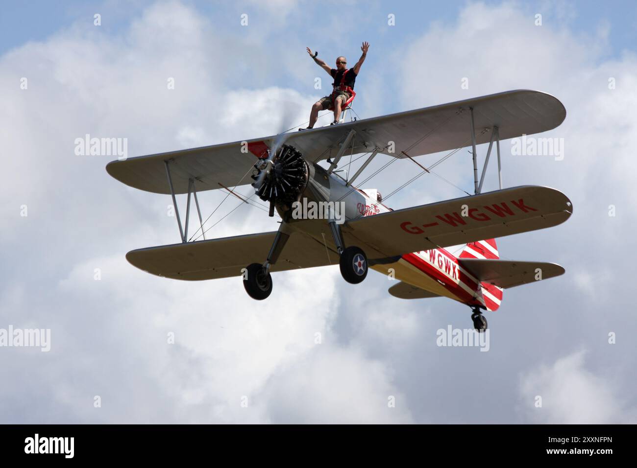 Un camminatore delle ali si gode un giro su un Boeing A-75L300 Stearman della Wing Walk Company presso l'Headcorn Aeodrome nel Kent Foto Stock