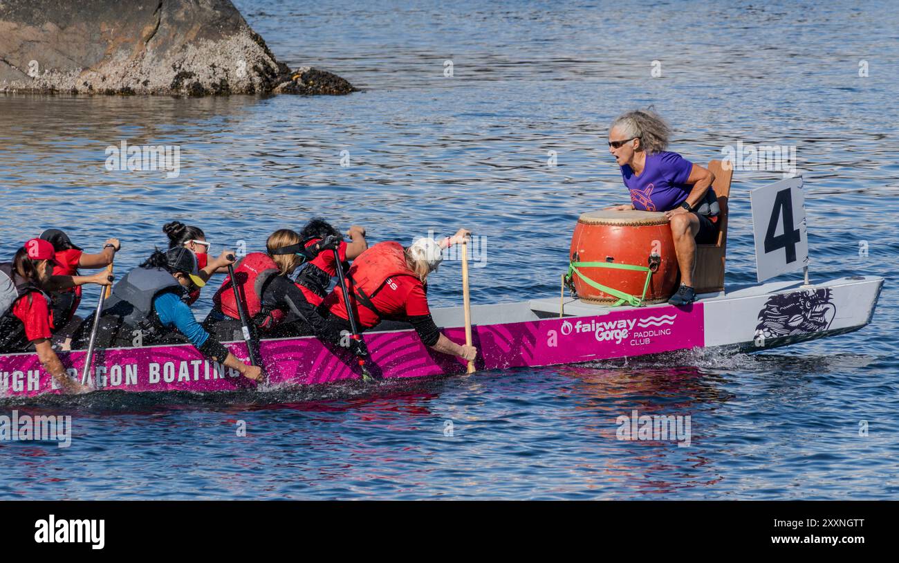 I membri del team di Dragon boat pagaiano in una gara nella Gorge Waterway a Victoria, British Columbia, Canada il 25 agosto 2024. Foto Stock