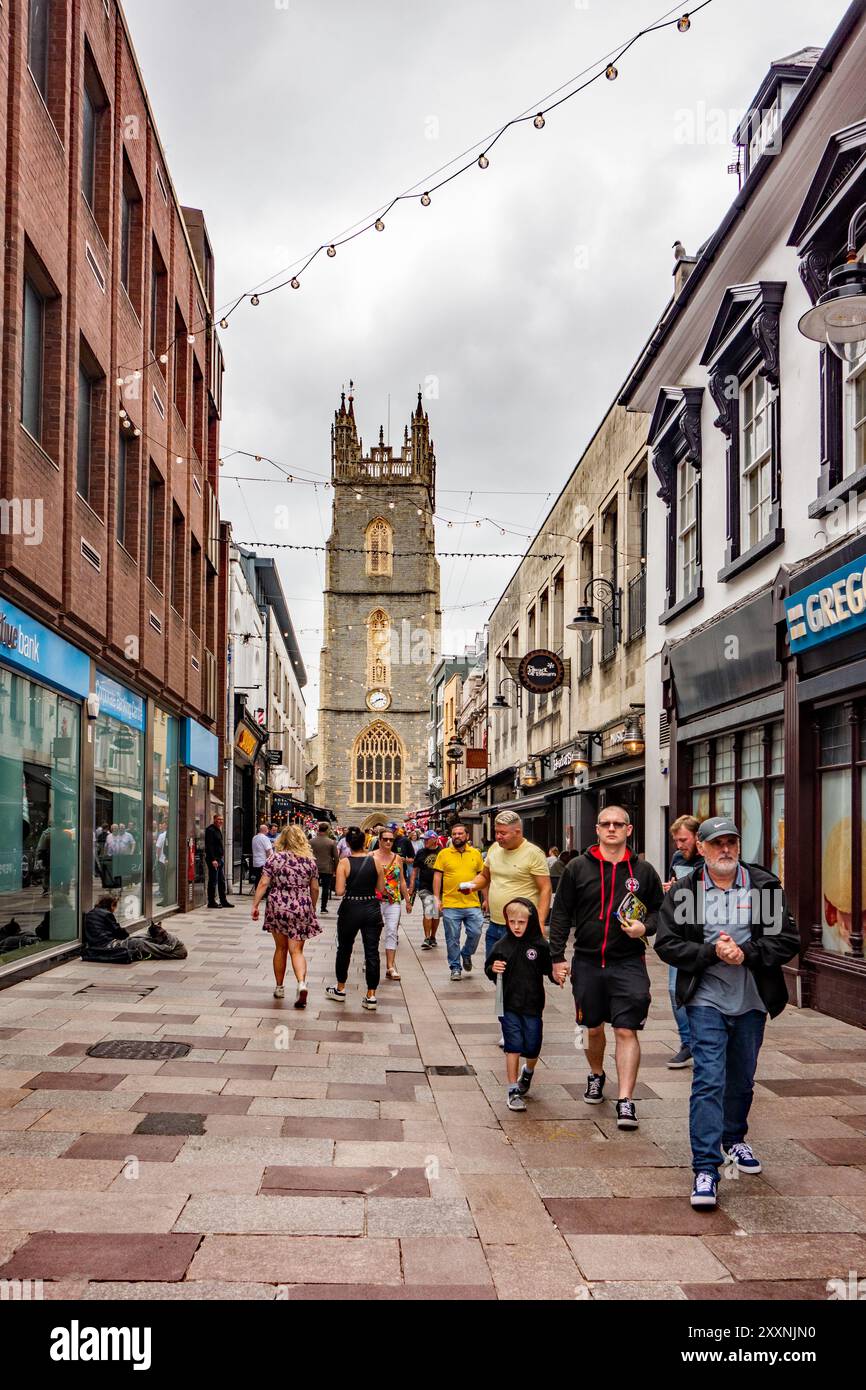 Gli amanti dello shopping e della gente in Church Street, nella capitale gallese di Cardiff, con vista sulla chiesa parrocchiale di St John the Baptist City, Galles Foto Stock