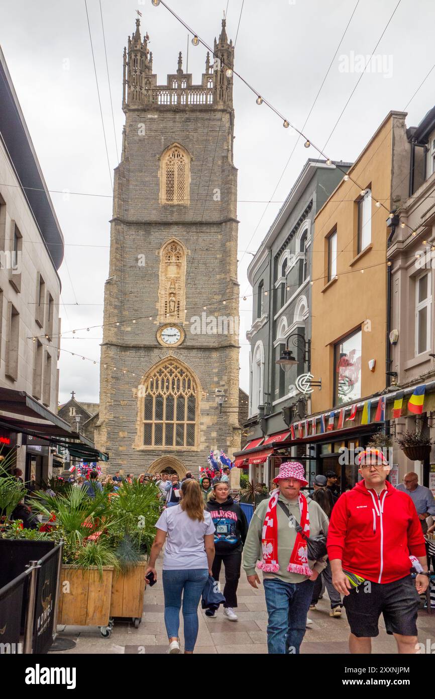Gli amanti dello shopping e della gente in Church Street, nella capitale gallese di Cardiff, con vista sulla chiesa parrocchiale di St John the Baptist City, Galles Foto Stock