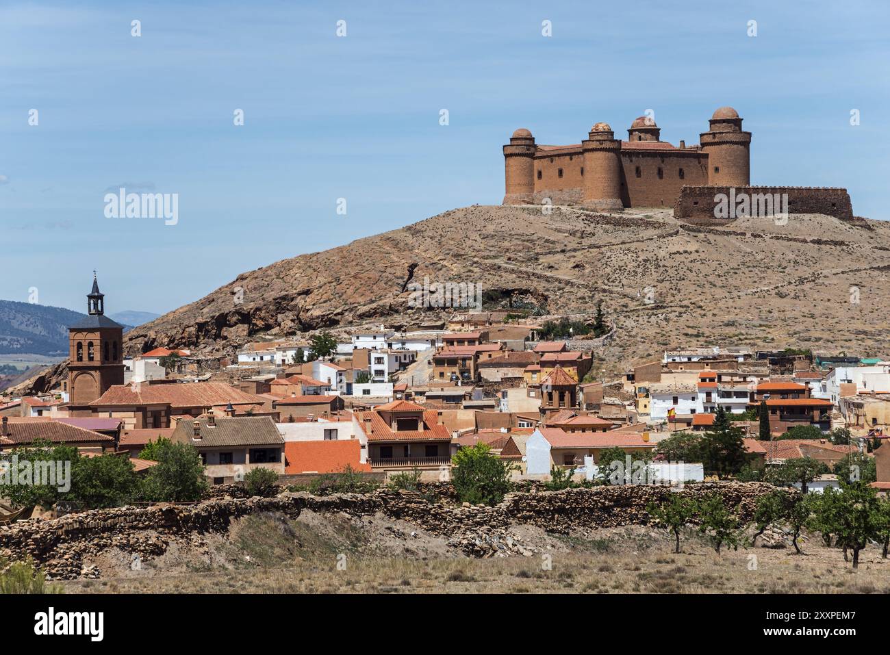 Castello medievale su una collina sopra una piccola città con case colorate e una chiesa, condizioni chiare e soleggiate, Castillo de la Calahorra, Calahorra, Granada Foto Stock
