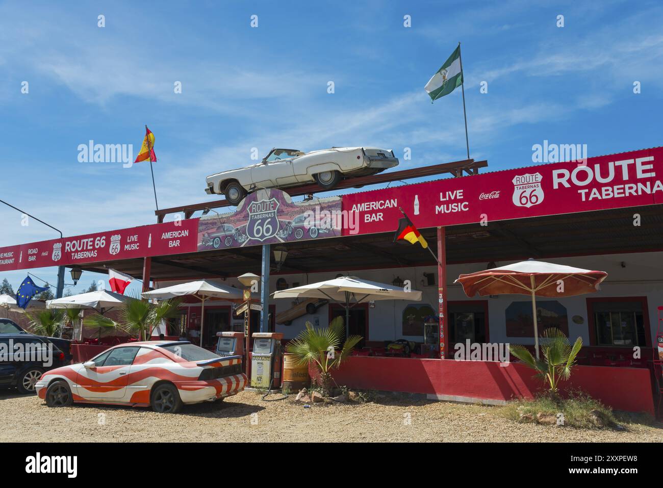 Una taberna retrò in stile Route 66 con bandiere, automobili e ombrelloni sotto un cielo blu, deserto di Tabernas, Desierto de Tabernas, Tabernas, Almeria, Andalusia, SP Foto Stock