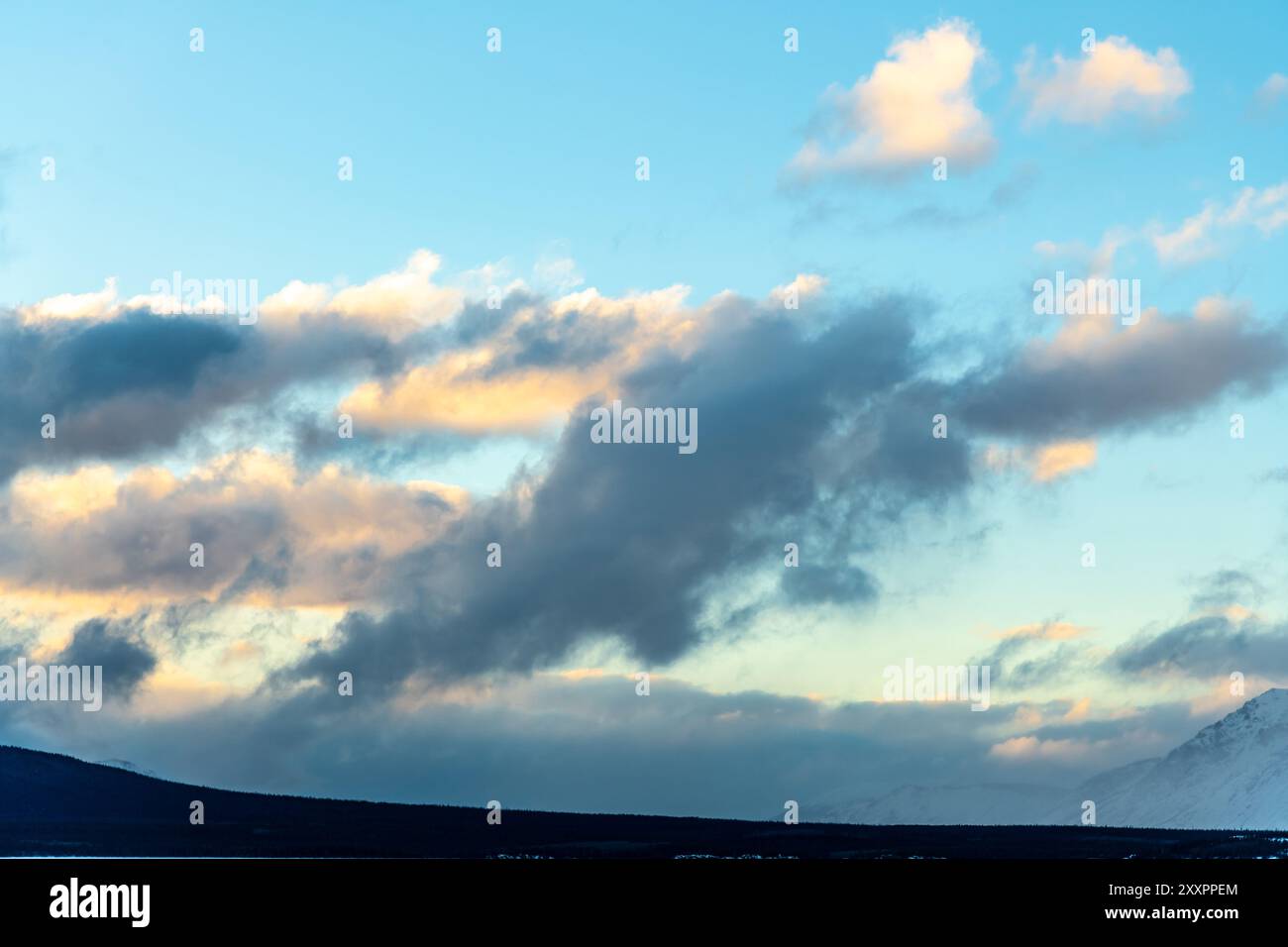 Cielo blu con nuvole bellissime e irregolari per l'uso sostitutivo del cielo. Preso nella stagione invernale nel nord del Canada con cieli di uccelli rossi Foto Stock