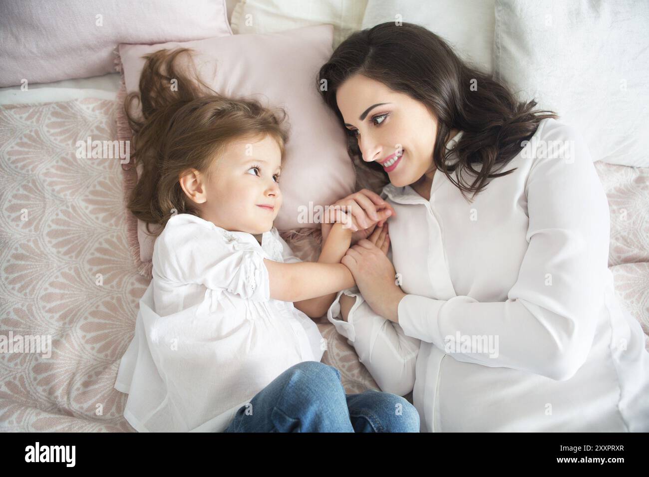 Giovane donna felice abbracciare con piccola figlia. Amore e il concetto di famiglia Foto Stock