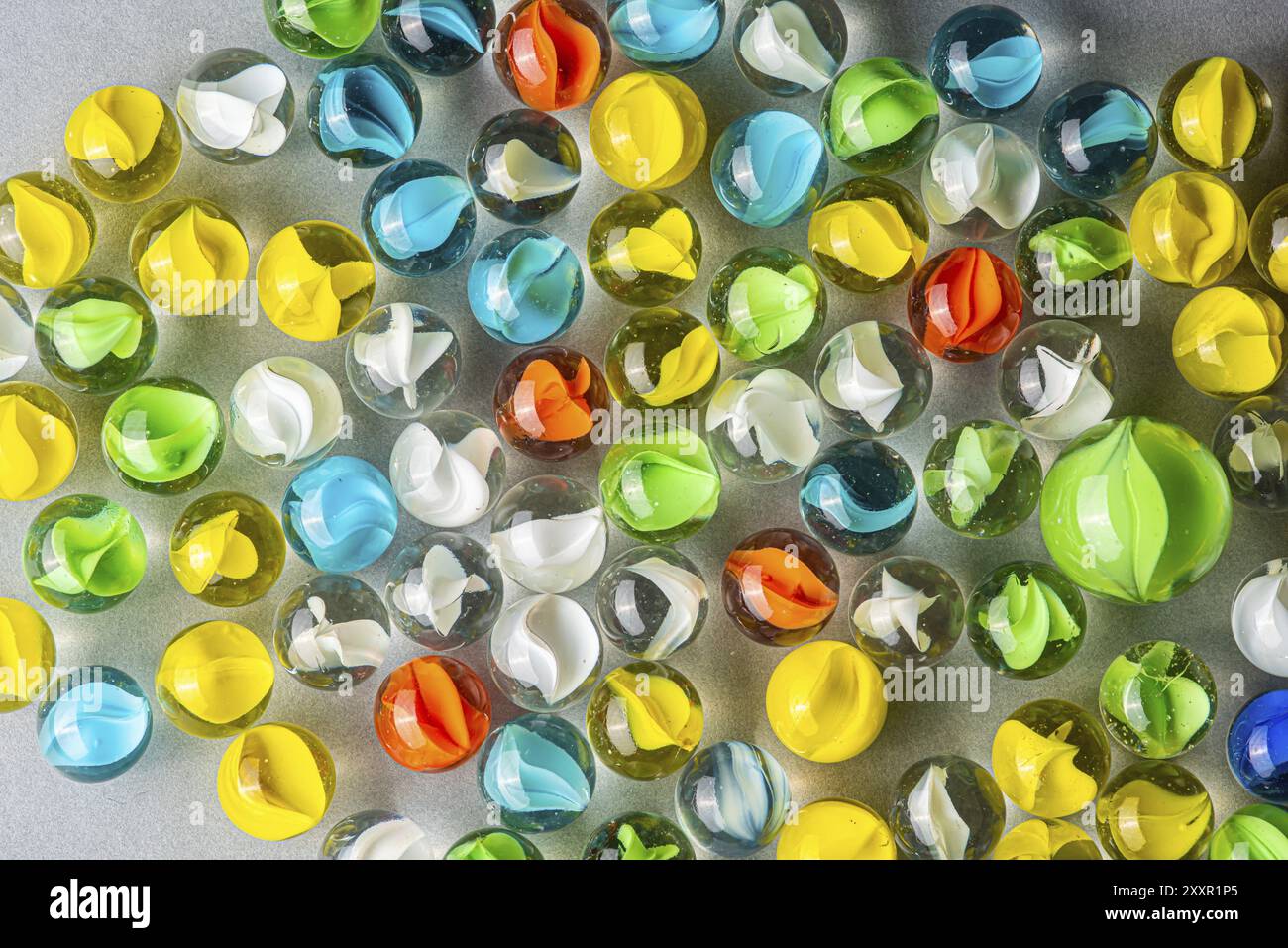 Marmi di vetro gialli, verdi, blu e rossi su un tavolo Foto Stock