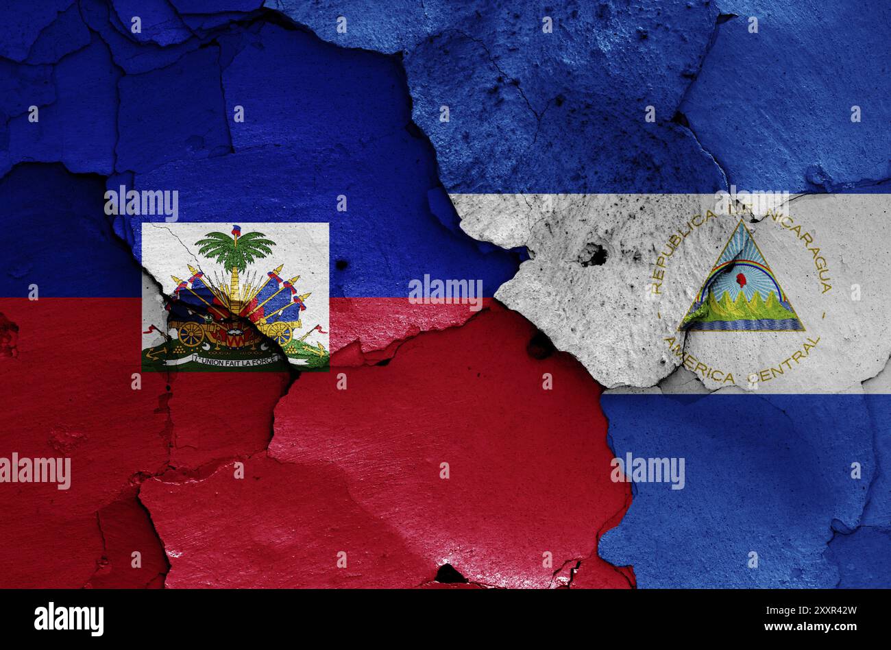 Bandiere di Haiti e Nicaragua dipinte su un muro incrinato Foto Stock