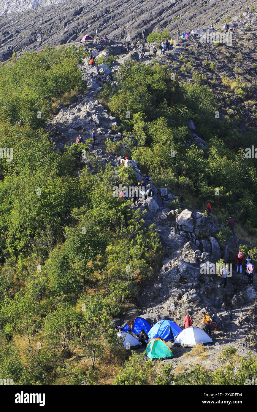 Gli scalatori allestiscono tende lungo il percorso di arrampicata fino alla cima del monte Merapi. Foto Stock