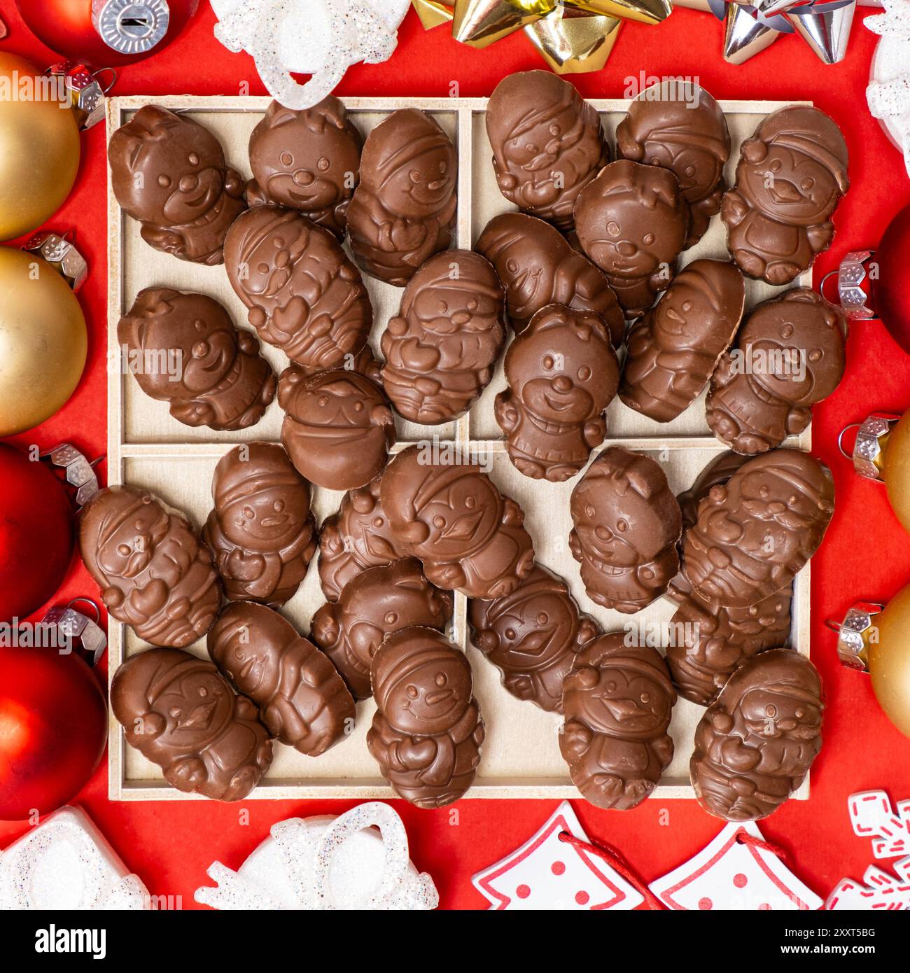 Cioccolatini a forma di figure natalizie sulla vista dall'alto su sfondo rosso Foto Stock