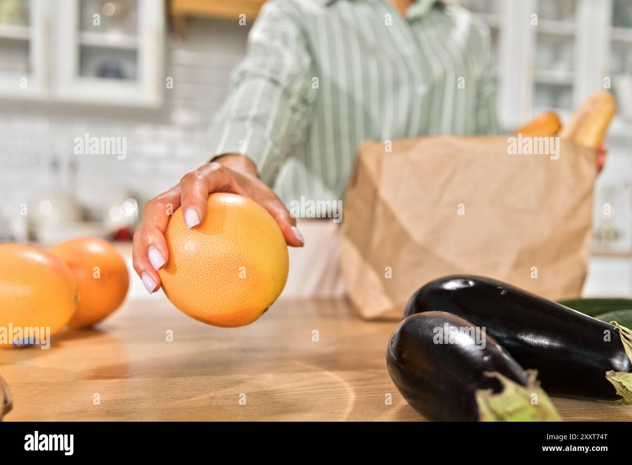 Madre afroamericana che prepara la spesa in cucina Foto Stock