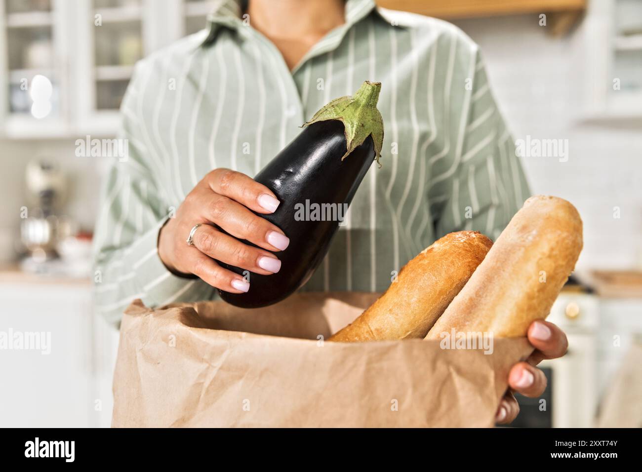 Madre afroamericana che prepara la spesa in cucina Foto Stock