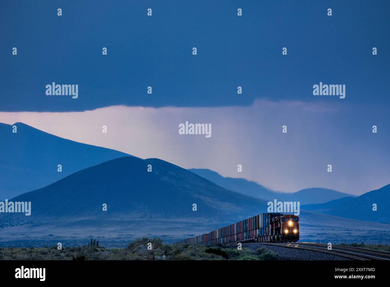 Vista compressa di un treno merci contro le montagne blu Foto Stock