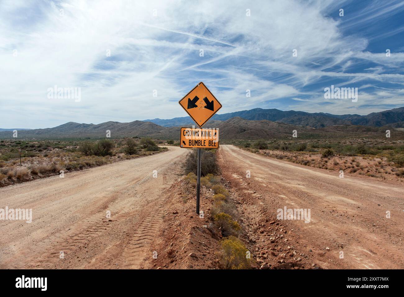 Cartello stradale al centro di due strade sterrate Foto Stock