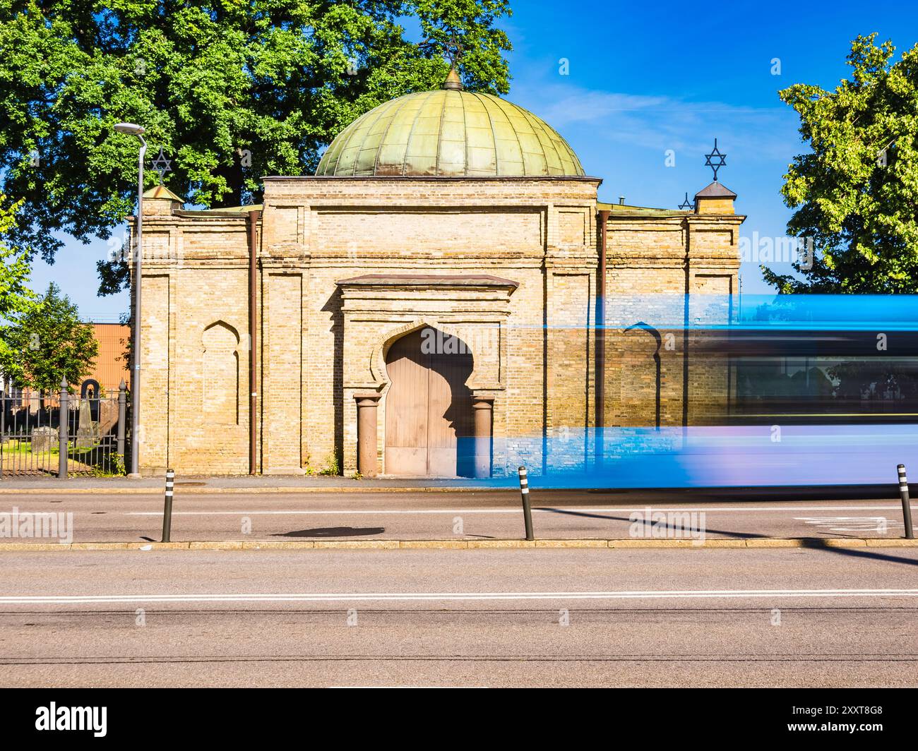 Un autobus blu accelera in un antico edificio unico a Gothenburg, Svezia, che mescola la vibrante energia dei trasporti urbani con l'architettura storica sotto a. Foto Stock