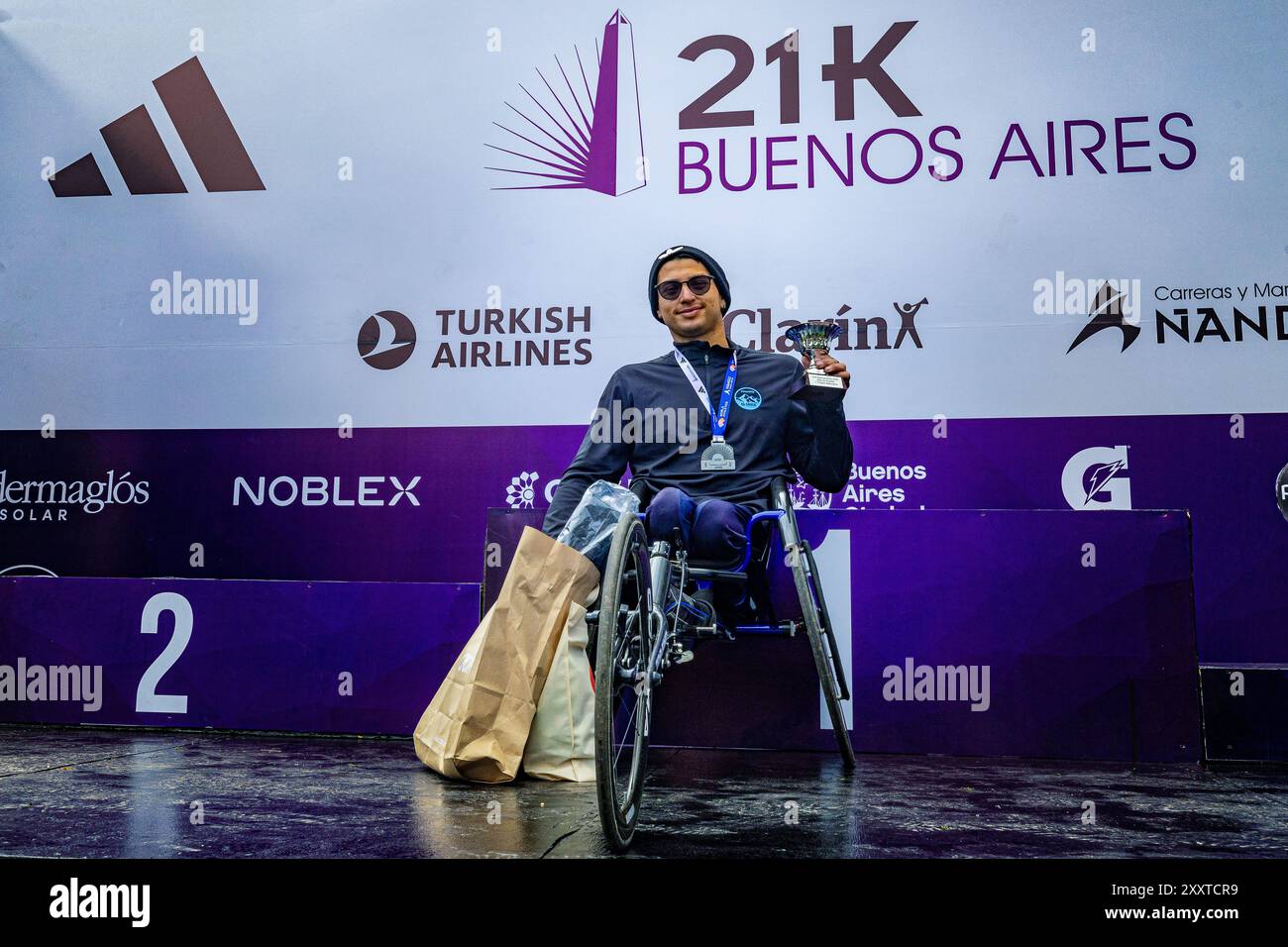 Buenos Aires, Argentina. 25 agosto 2024. L'argentino Gabriel Sosa sorride e mostra la coppa che ha vinto per il primo posto nello sport adattato. La nuova edizione della Buenos Aires City Half Marathon è un evento da record con più di 25.000 partecipanti e 4.146 stranieri. Quest'anno, la 21k è stata scelta da World Athletics come una delle 10 migliori gare al mondo, essendo la più popolare in Sud America. Il circuito passa attraverso quartieri emblematici della città. Credito: SOPA Images Limited/Alamy Live News Foto Stock