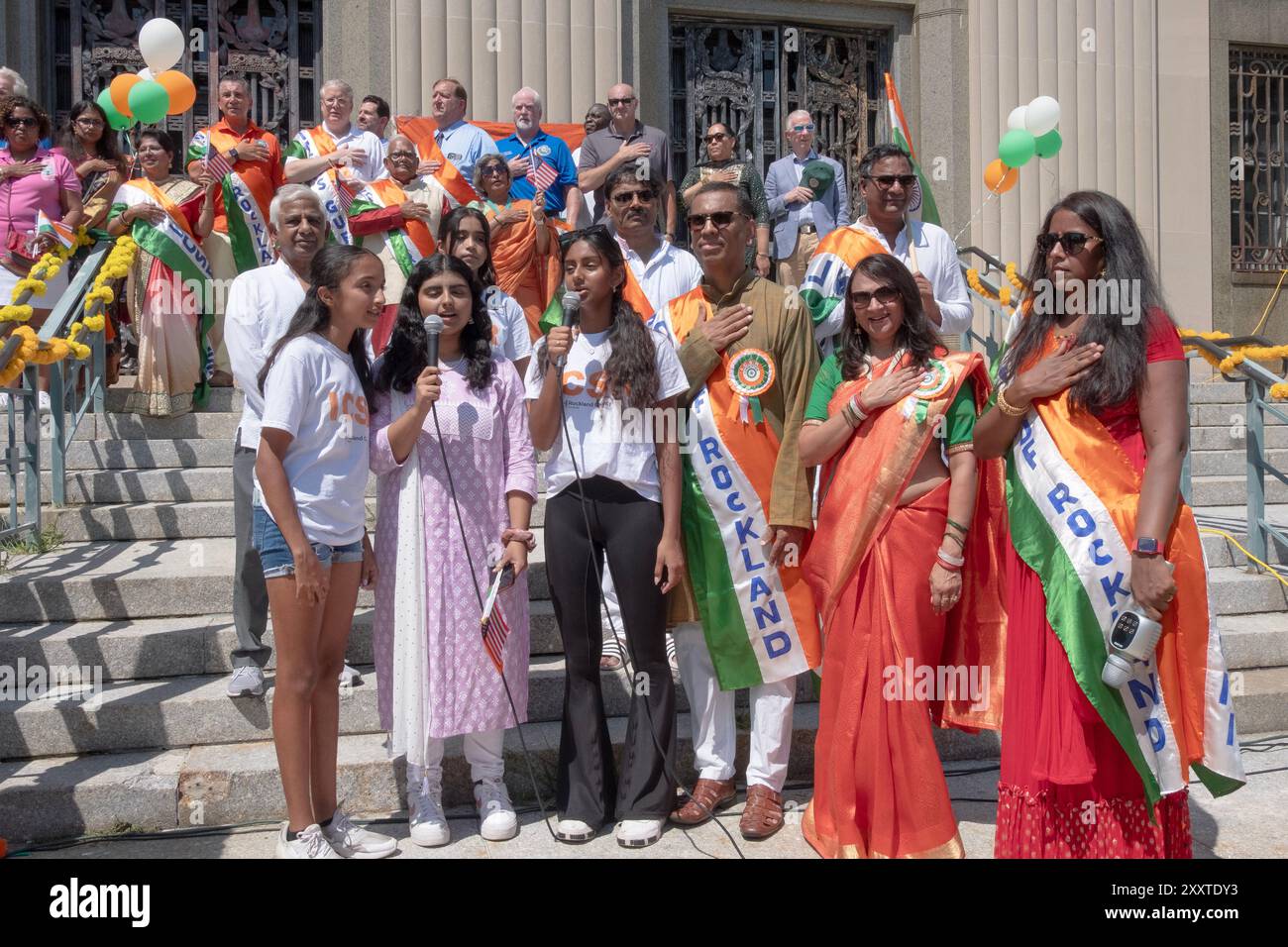 Gli indù americani di tutte le età cantano l'inno nazionale sui gradini del tribunale della contea di Rockland come parte della parata del giorno dell'indipendenza dell'India. Foto Stock