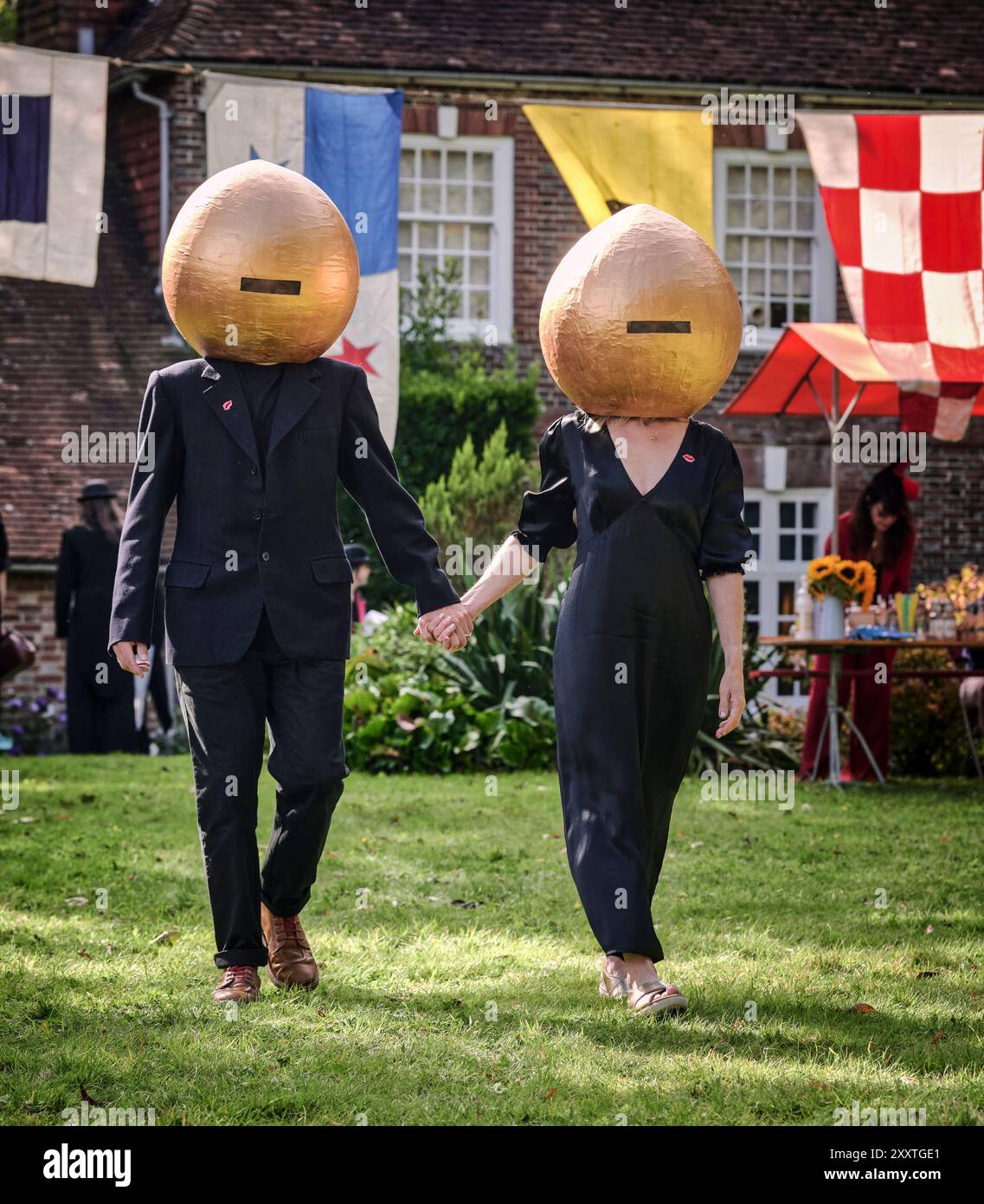 Muddles Green, Regno Unito. 25 agosto 2024. Gli ospiti dell'annuale picnic surrealista nei giardini di Farleys House onorano la storia di questo affascinante movimento artistico del XX secolo in stile sartoriale. Una volta casa del fotografo surrealista Lee Miller e del suo marito artista, Roland Penrose, Farleys House, che rimane nella famiglia Penrose, era stato un luogo di incontro per molti artisti importanti del movimento, tra cui Pablo Picasso, Max Ernst, Joan Miró e Man Ray. Quest'anno Farley Farm festeggia il suo 75° anniversario come la casa dei surrealisti. Crediti: Jim Holden/Alamy Live News Foto Stock