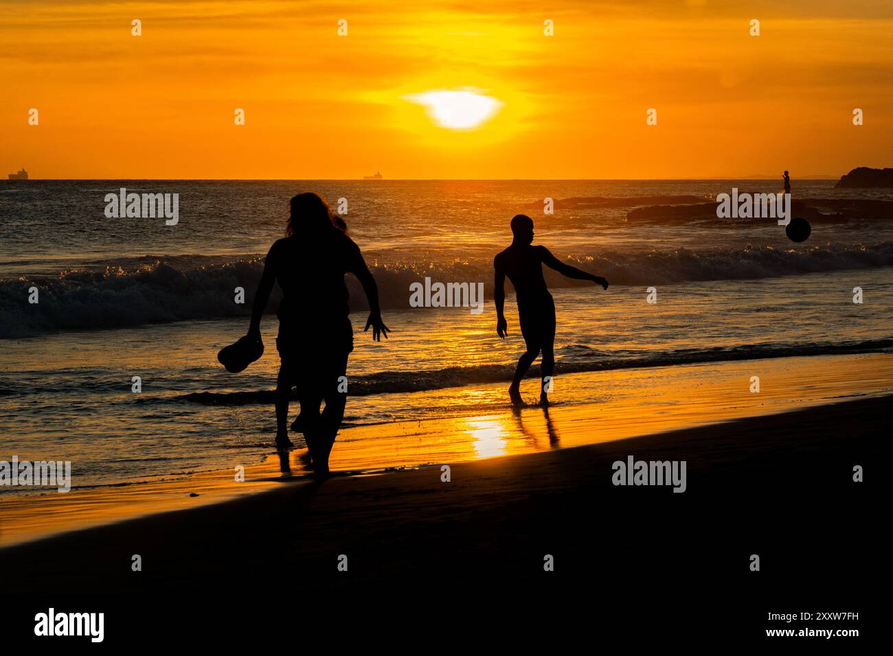 Salvador, Bahia, Brasile - 6 dicembre 2019: I bagnanti si divertono al tramonto sulla spiaggia di Farol da barra nella città di Salvador, Bahia. Foto Stock