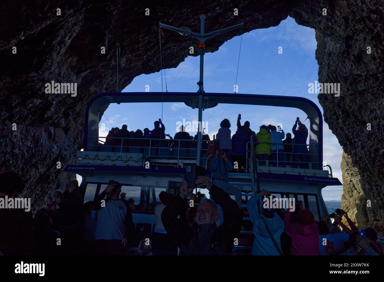 Northland, Bay of Islands, North Island, nuova Zelanda - una nave da crociera passa attraverso l'arco naturale chiamato Hole in the Rock nell'Isola di Piercy Foto Stock