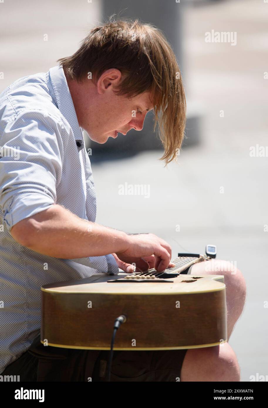 Londra, Regno Unito. Busker a Trafalgar Square che suona la chitarra con tecnica di percussione in stile lap Foto Stock