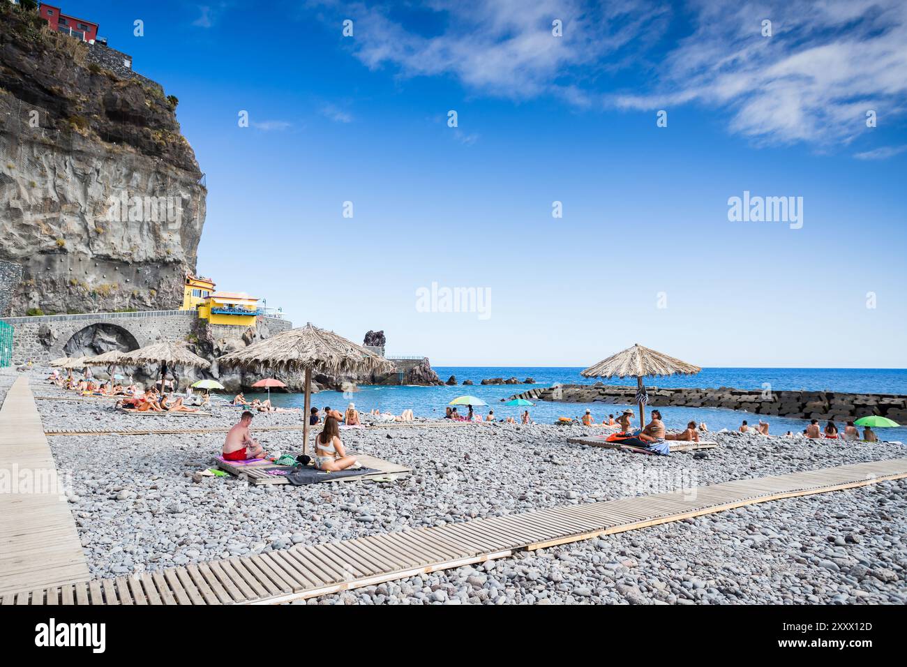 Persone che si godono il sole del tardo pomeriggio a Ponta do Sol, Madeira, il 1° agosto 2024. Questo villaggio è conosciuto come il luogo più soleggiato dell'isola. Foto Stock